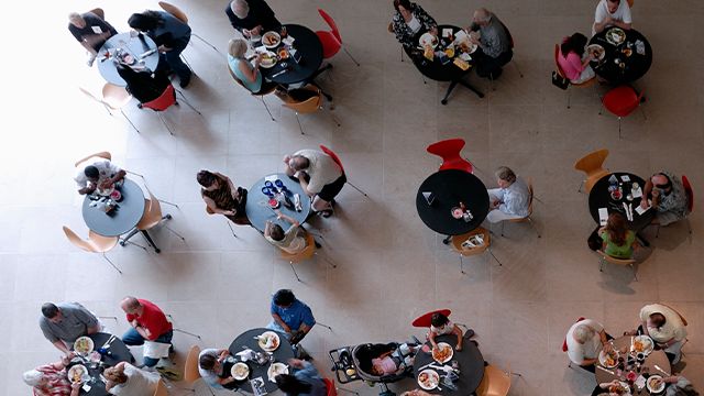 Groups of people sitting around small tables