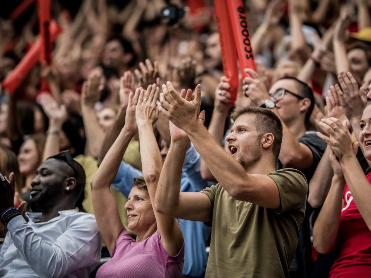 A photo of a crowd cheering and clapping at a sports event