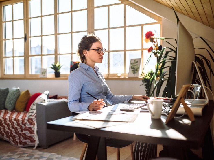 Woman working at desk sunny room