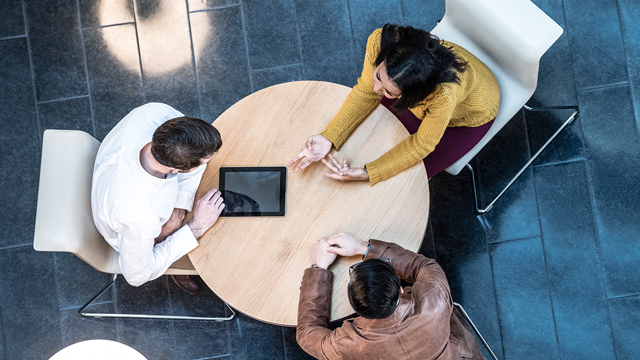 Three colleagues sitting together at a round table